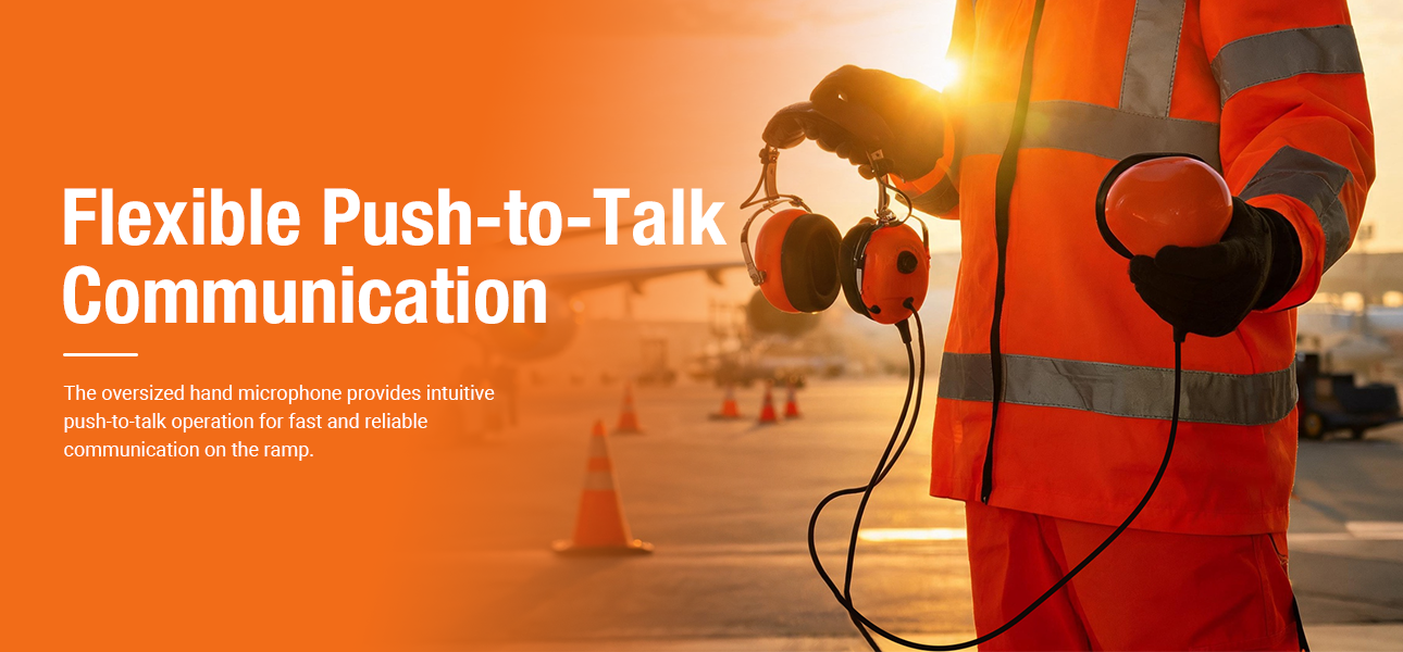 Ground crew holding the PH-210 ground support headset with an oversized push-to-talk microphone, communicating on an airport ramp.